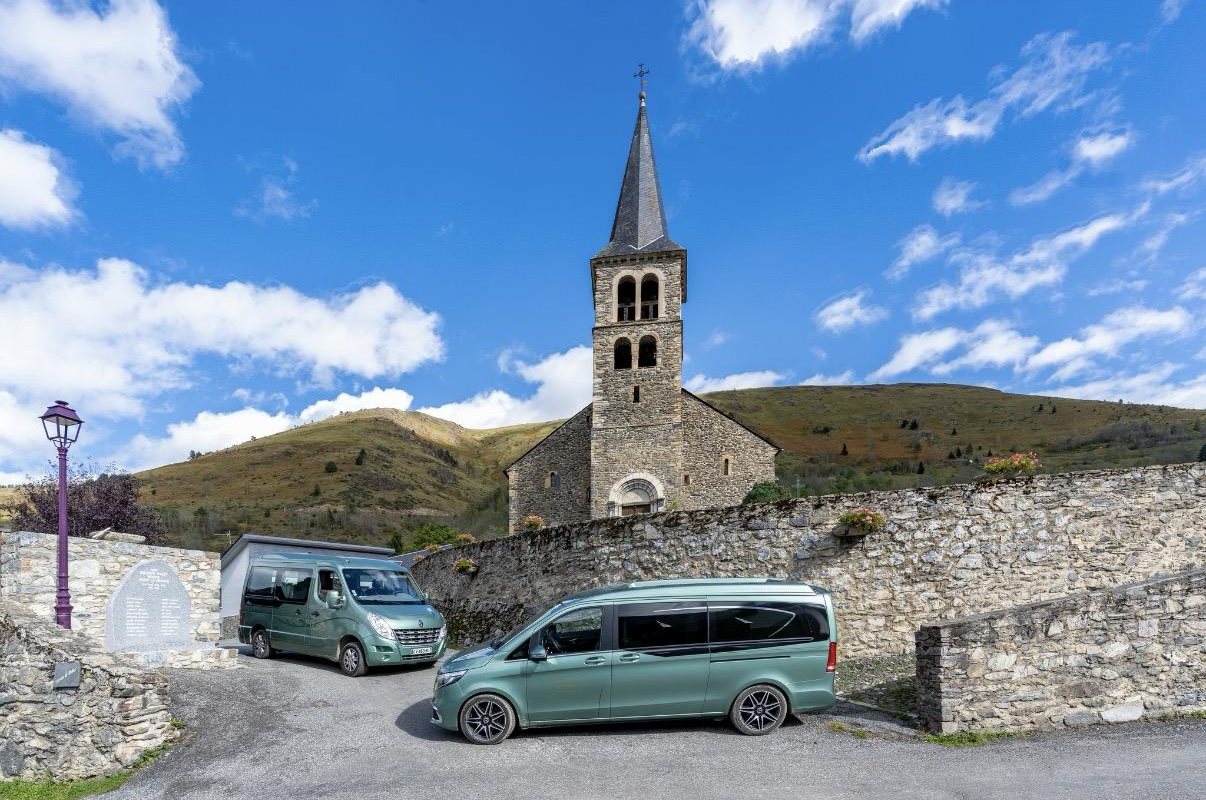 Véhicules funéraires Jacomet devant une église de montagne